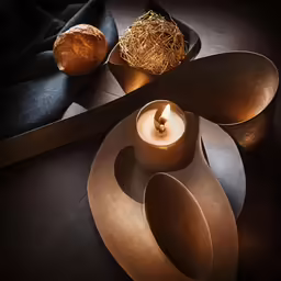 a candle with two different shaped dishes surrounding it