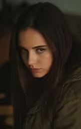a woman in a jacket looks at the camera