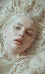 a blonde haired woman laying down in a blanket