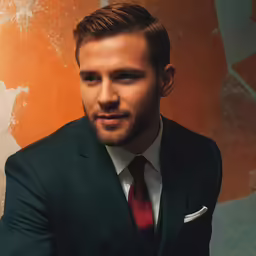 a young man is dressed in a business suit and tie