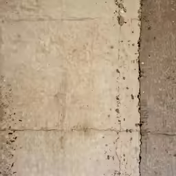 a yellow bus is next to an old white wall