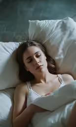 woman sleeping on pillow with sheets pulled up over her head