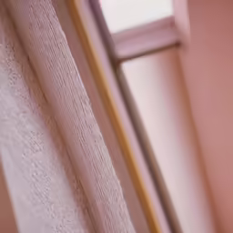 an up close shot of a window with a curtain