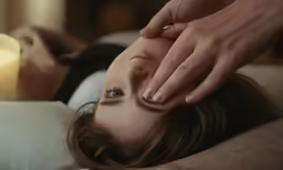 a woman lies in bed and is being examined by a nurse