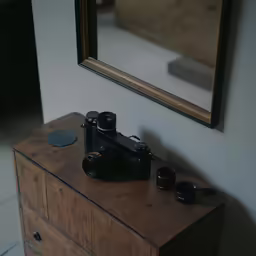 a black camera is sitting on top of a chest of drawers