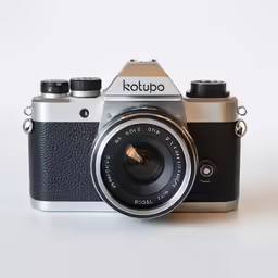 a silver and black camera on a white table