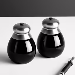 a pen is next to two black vases