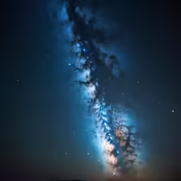 a very long dark column lit by stars in the sky