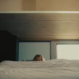 woman in white bed with white sheets, window open