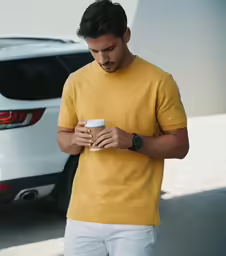 the man is holding his cup of coffee in hand