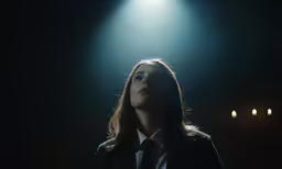 woman with neck tie standing in front of spotlights