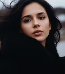 a woman with dark hair is outside posing