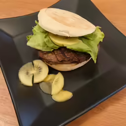 the hamburger on the plate is being eaten