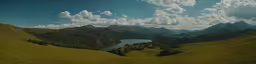 a view of a valley and water surrounded by mountains