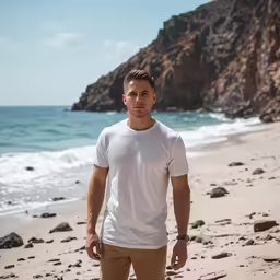 young man walking on the beach with ocean in background