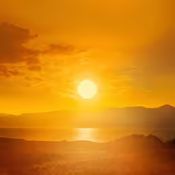 a sun that is setting over some water