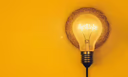 an illuminated light bulb placed on the wall