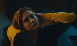 a woman sitting on a couch in a dark room