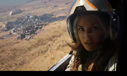 woman with helmet riding over arid terrain from plane
