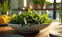 a bowl of fresh green lettuce sits on a wooden table
