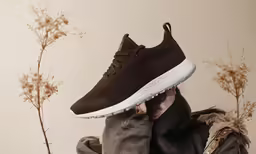 a man is wearing a brown sneaker over his head