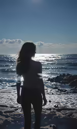 a person on the beach in the sand with sun shining