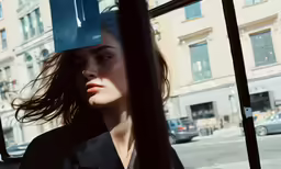 a woman with her hair blowing in the wind from a bus
