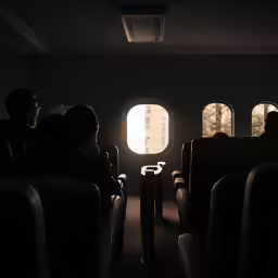 three people sitting in an airplane at night