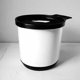 black and white trash can next to wall
