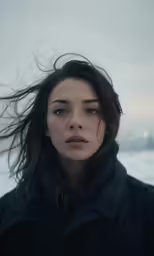 a young woman with black coat on snowy surface