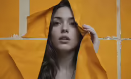woman wearing yellow cloth covering her face with hand