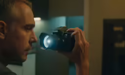 a man looking in the mirror with his camera attached