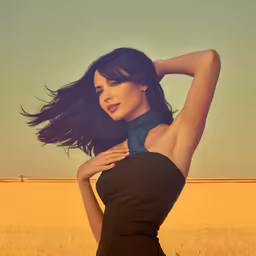 a woman posing in an off shoulder dress