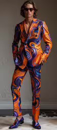 a male in a brightly colored suit and sunglasses,a man wearing an orange and blue suit
