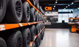 some tires are shown on some shelves and some people