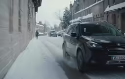 a black car driving down the street during the winter