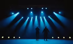 two people in a stage with lights coming out of them