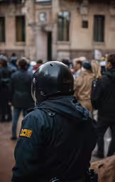 police officers stand near other people walking in line,police stand in a crowd outside a large building