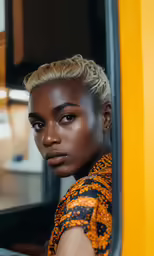 a young woman with an afro looks into the mirror