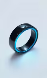 a black, blue and silver ring sits on a white surface