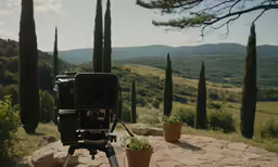 a camera set up on a tripod next to a bush