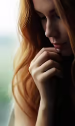 a young red headed woman with her hands on her chin