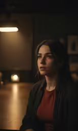 a woman in a dark room is staring at something