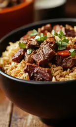 a bowl of rice and meat with herbs