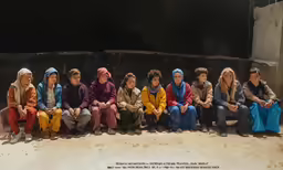 a group of women sitting in front of one another