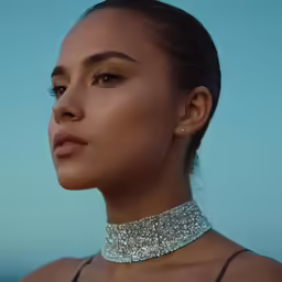 a woman wearing silver choker necklace looking away