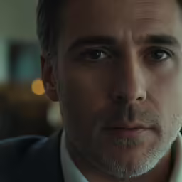 a man wearing a suit staring into the camera