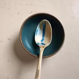 a spoon sitting in a small bowl, one is empty