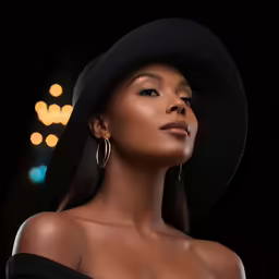 a woman with a black hat on, in the dark
