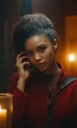 an attractive young woman with curly hair is holding a cellphone up